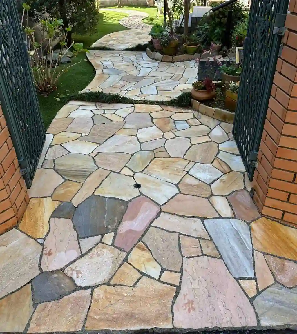 A stone walkway with a gate and a garden after cleaning. Complete difference.